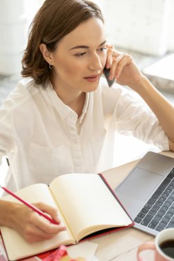 Akıllı telefondan konuşan meşgul genç bayan.