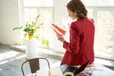 Masada oturan genç bayan tasarımcı.