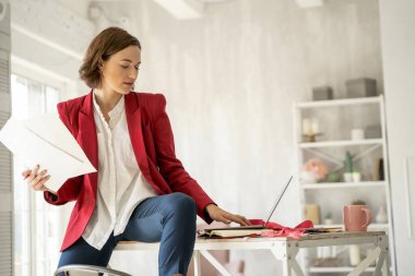 Dizüstü bilgisayarına bakan ciddi bir kadın.