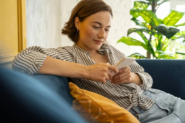 Wanita dengan smartphone di sofa — Stok Foto