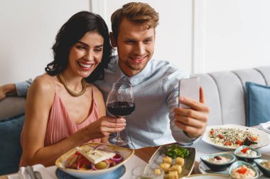 Restoranda selfie çeken mutlu genç çift.