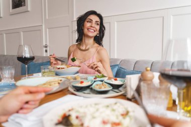 Çekici genç bir kadın restoranda yemek yiyor.