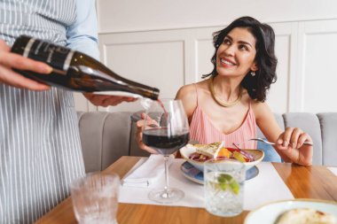 Garson restoranda hoş bir bayana şarap servisi yapıyor.