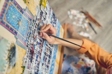 Yetenekli kadın ressam evde güzel soyut resimler çiziyor.