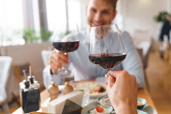 Jovem e mulher brindam com vinho no restaurante — Fotografia de Stock