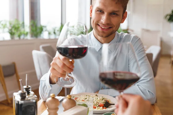 Fešák mladý muž a žena toasting s vínem v restauraci — Stock fotografie