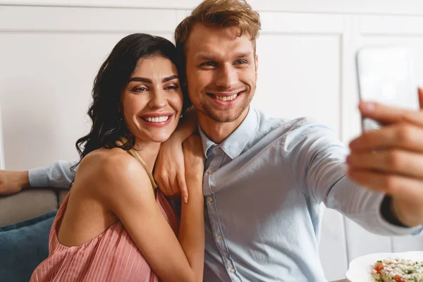 Beautiful young couple making selfie in cafe — Stock Photo, Image