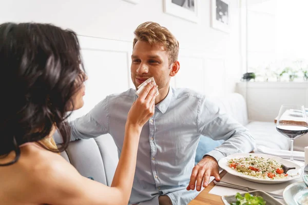 Joven dama limpiando boca caballero con servilleta en la cafetería —  Fotos de Stock