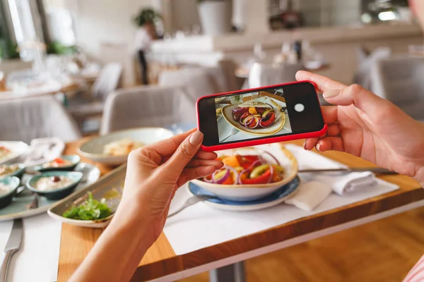 Mujer joven tomando fotos de la comida del almuerzo con teléfono móvil —  Fotos de Stock