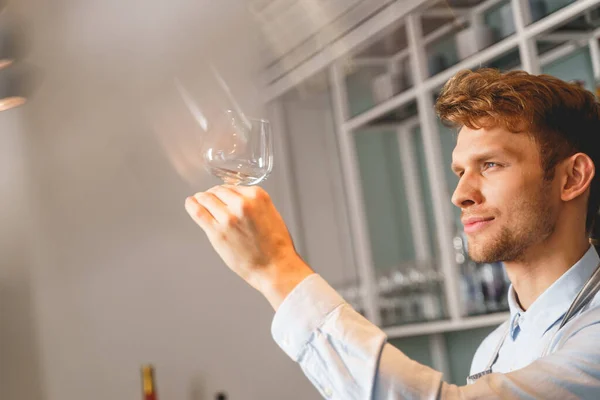 Bonito jovem segurando copo de vinho perfeitamente limpo — Fotografia de Stock