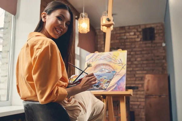 Glada ung kvinna rita bild med färger hemma — Stockfoto