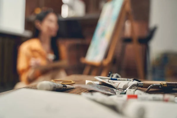 Tubos de pintura y paleta cuchillos en la mesa en el estudio de arte en casa —  Fotos de Stock
