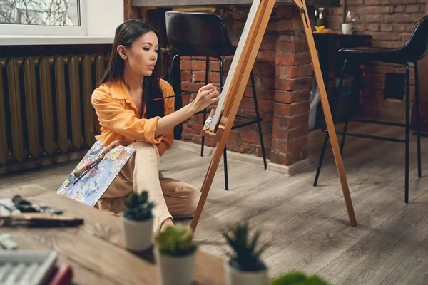 Attraente quadro giovane donna pittura in studio d'arte a casa — Foto Stock