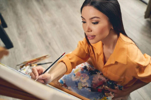 Attraktive Dame zeichnet mit Acrylfarben zu Hause — Stockfoto