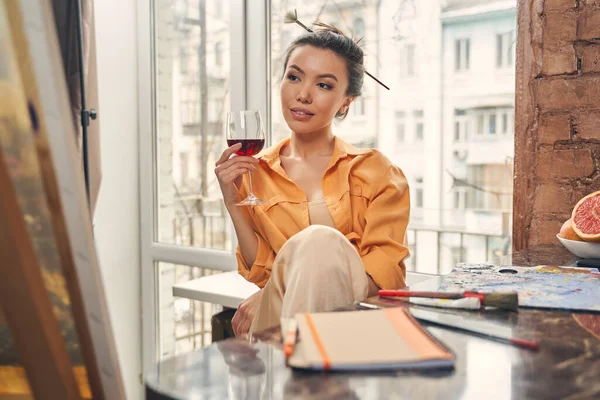 Привлекательная молодая женщина пьет вино дома — стоковое фото