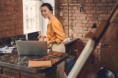 Güzel bayan mutfakta arkadaşlarıyla görüntülü konuşma yapıyor.