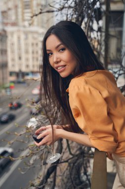 Balkonda duran şarap kadehiyle güzel bir bayan.