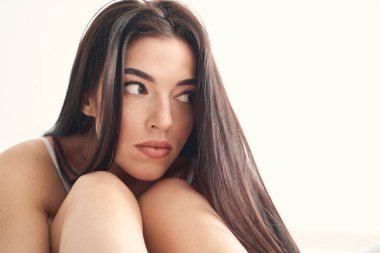 Bunalımlı, siyah saçlı, beyaz kadın, yapayalnız oturuyor.