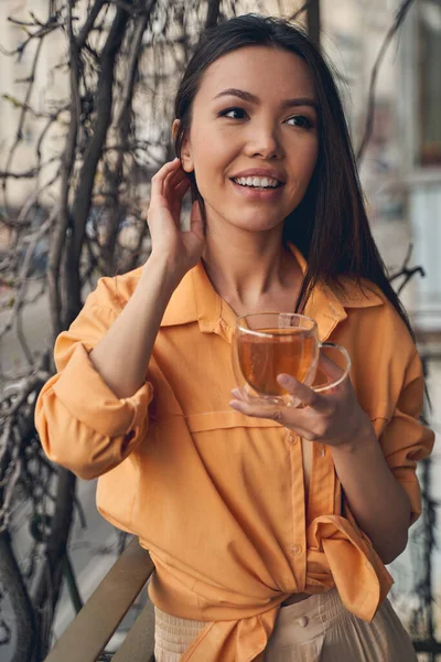 Atractiva joven mujer disfrutando del té en el balcón — Foto de Stock