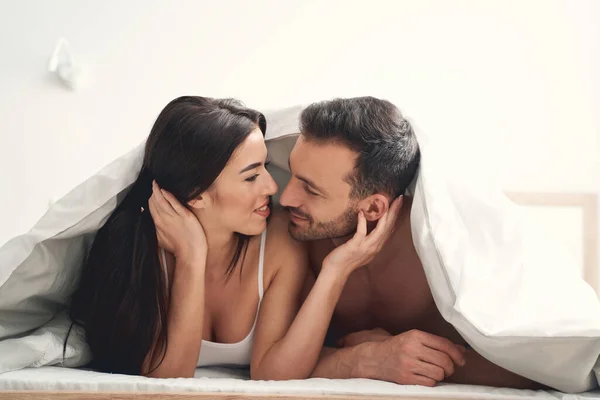 Glückliches Ehepaar liegt unter der Decke — Stockfoto