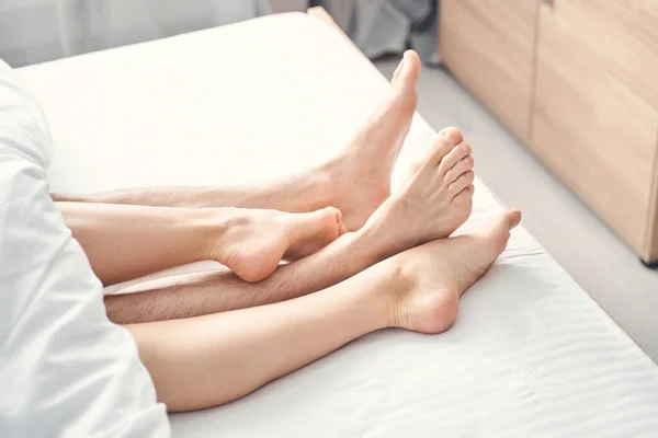 Мужчина и женщина лежат босиком в постели — стоковое фото