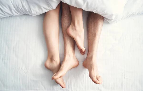 Recién casados que permanecen en la cama durante su luna de miel — Foto de Stock