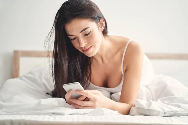 Señora leyendo un mensaje de texto en su celular — Foto de Stock