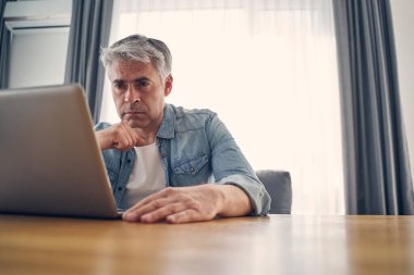 Ciddi bir beyaz erkek masada oturuyor ve şöyle düşünüyor: