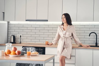 Güzel, genç bir eş mutfağa bakıyor.