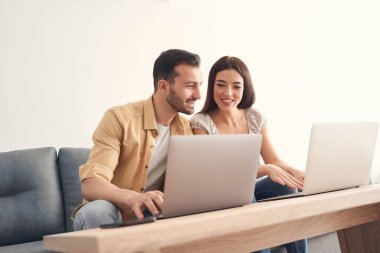 Genç adam ve kadın uzaktan çalışmada birbirlerine yardım ediyorlar.