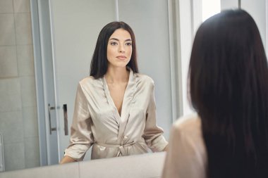 Banyodaki aynaya bakan çekici genç esmer.