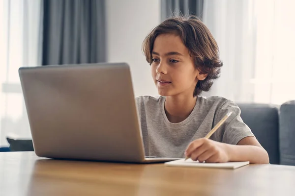 Счастливый маленький ребенок, пользующийся ноутбуком дома — стоковое фото
