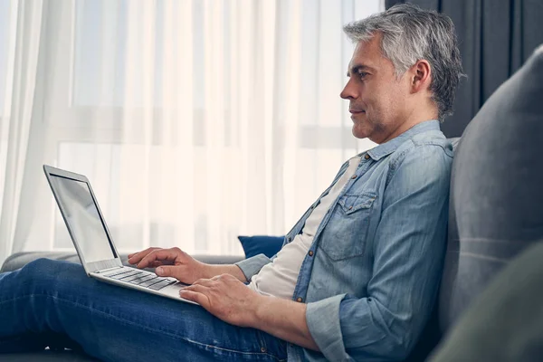 Привлекательный взрослый мужчина, работающий в Интернете и использующий компьютер — стоковое фото