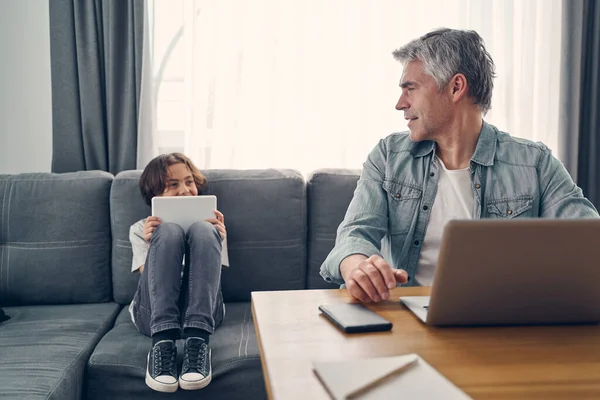 Счастливый человек разговаривает с сыном в гостиной — стоковое фото