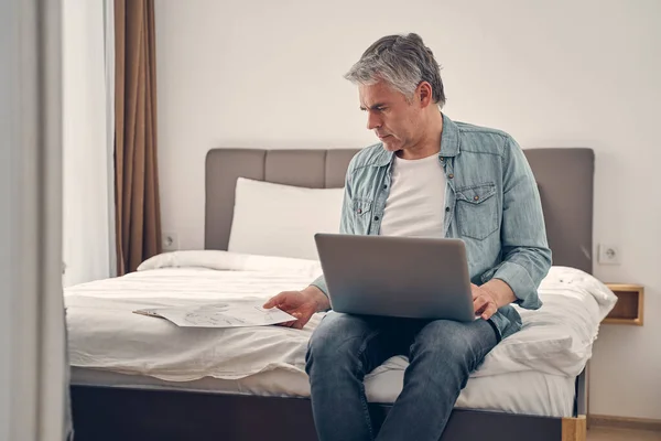 Hombre concentrado trabajando desde casa con dispositivo —  Fotos de Stock