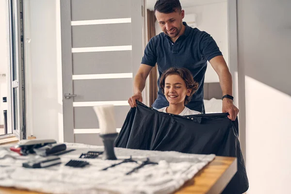 Hombre atractivo va a cortar el pelo de un niño pequeño — Foto de Stock