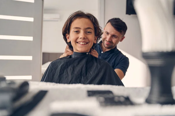 Pequena criança morena olhando alegremente antes do corte de cabelo — Fotografia de Stock