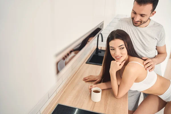 Passionate young couple in love hugging at kitchen — Stock Photo, Image