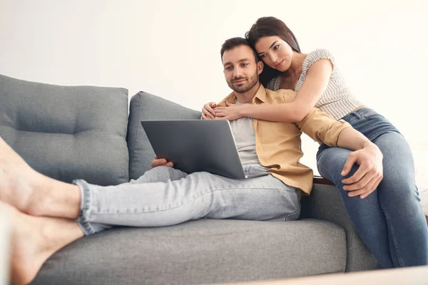 Щаслива молода пара в любові обіймається на дивані — стокове фото