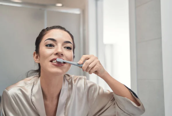 Aktív mosolygós fiatal női tisztító fogak fogkefével és pasztával — Stock Fotó