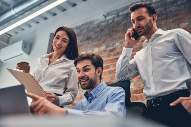 Genç iş arkadaşları ofiste yeni projeyi tartışıyor