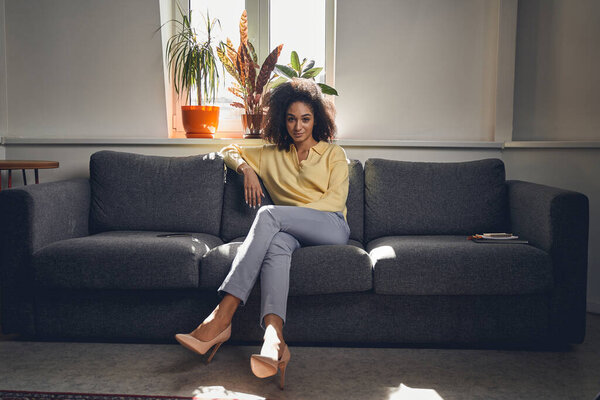 Стильная молодая женщина отдыхает на диване
