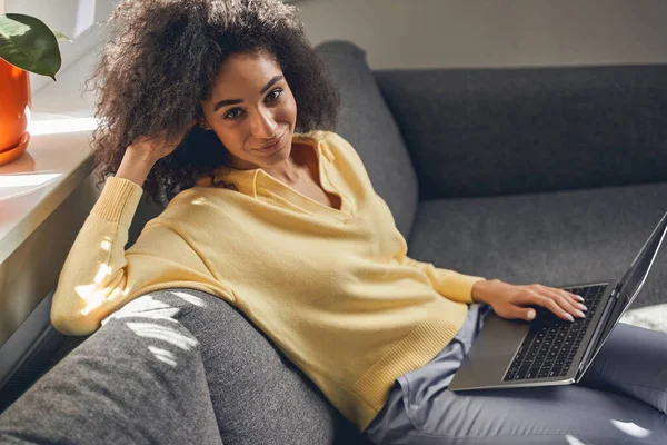 Adorável mulher de cabelos escuros contente com um laptop — Fotografia de Stock