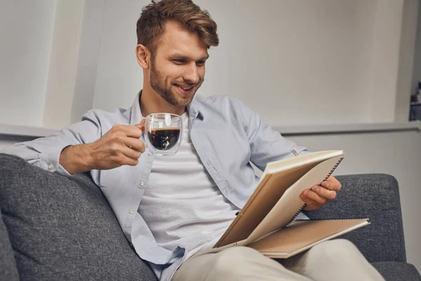 Sorrindo jovem empreendedor do sexo masculino lendo suas notas — Fotografia de Stock