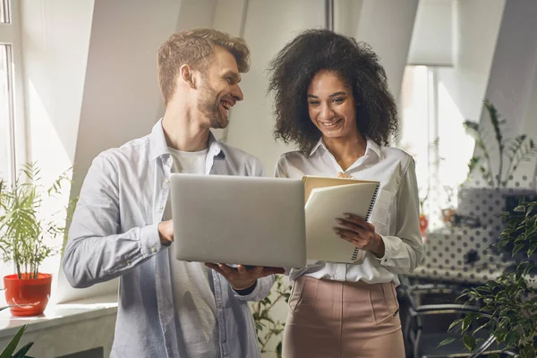 Mujer sonriente mirando a su colega portátil — Foto de Stock