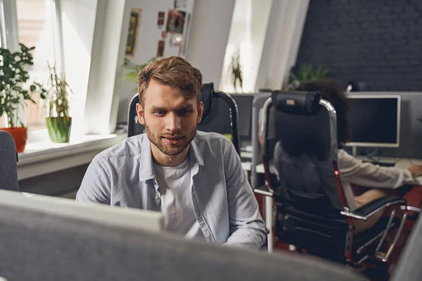 Zaměřený zaměstnanec se dívá na svůj notebook — Stock fotografie