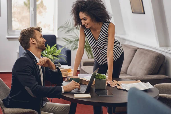 Vreugdevolle blanke werknemer zit aan het bureau — Stockfoto