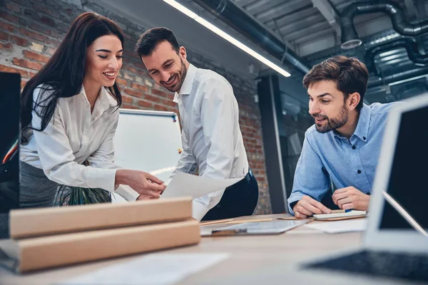 Glückliche Teamkollegen reden und sitzen im Büro — Stockfoto