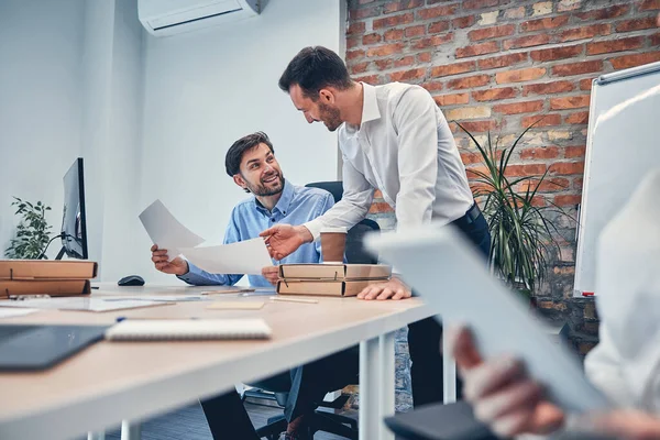 De jeunes partenaires élaborent un contrat dans un bureau moderne — Photo