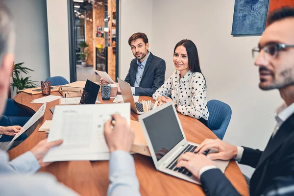 Compañeros sonrientes discutiendo un nuevo contrato en la sala de reuniones —  Fotos de Stock